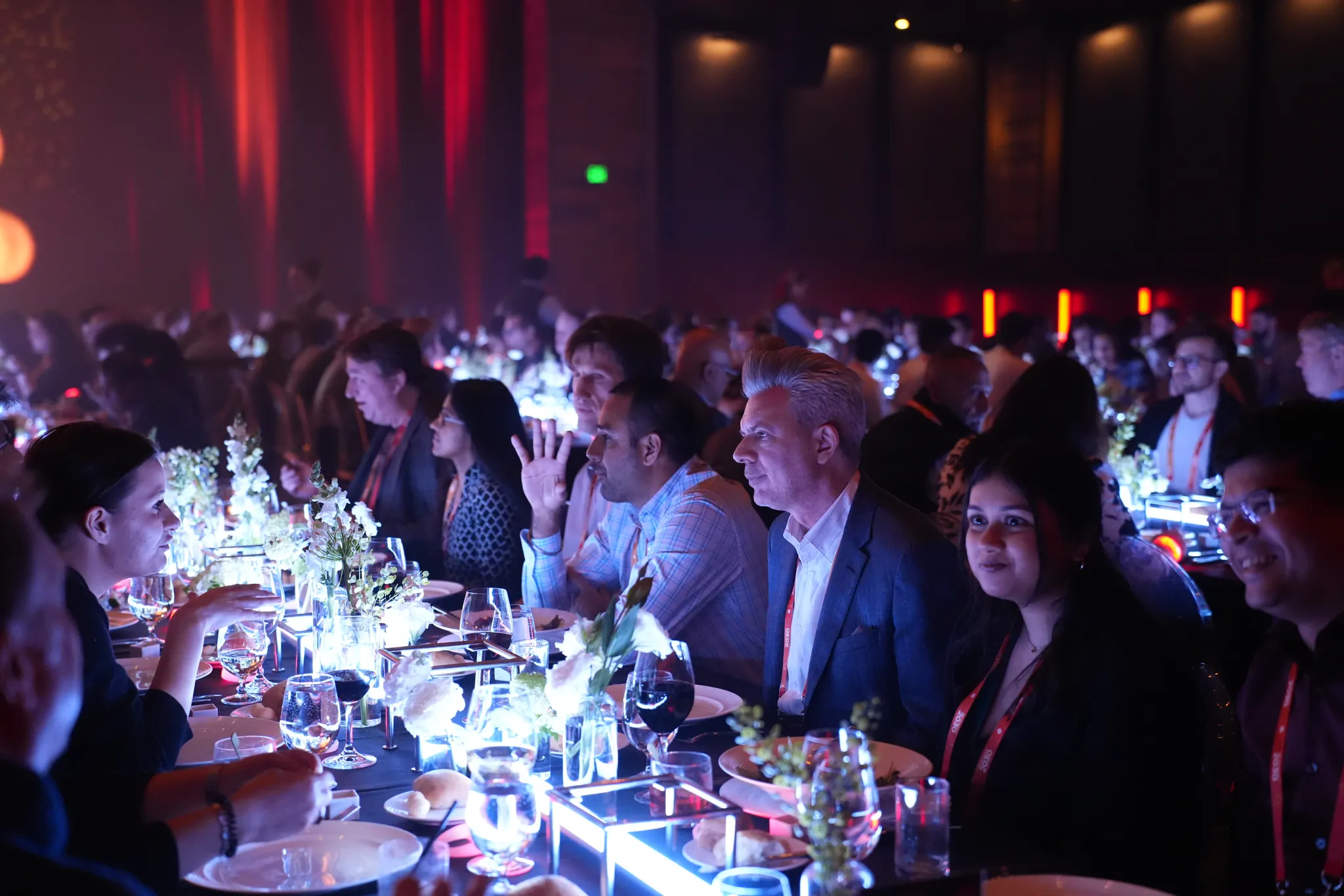 Couchbase Company Kickoff attendees at a recognition dinner under red event lighting
