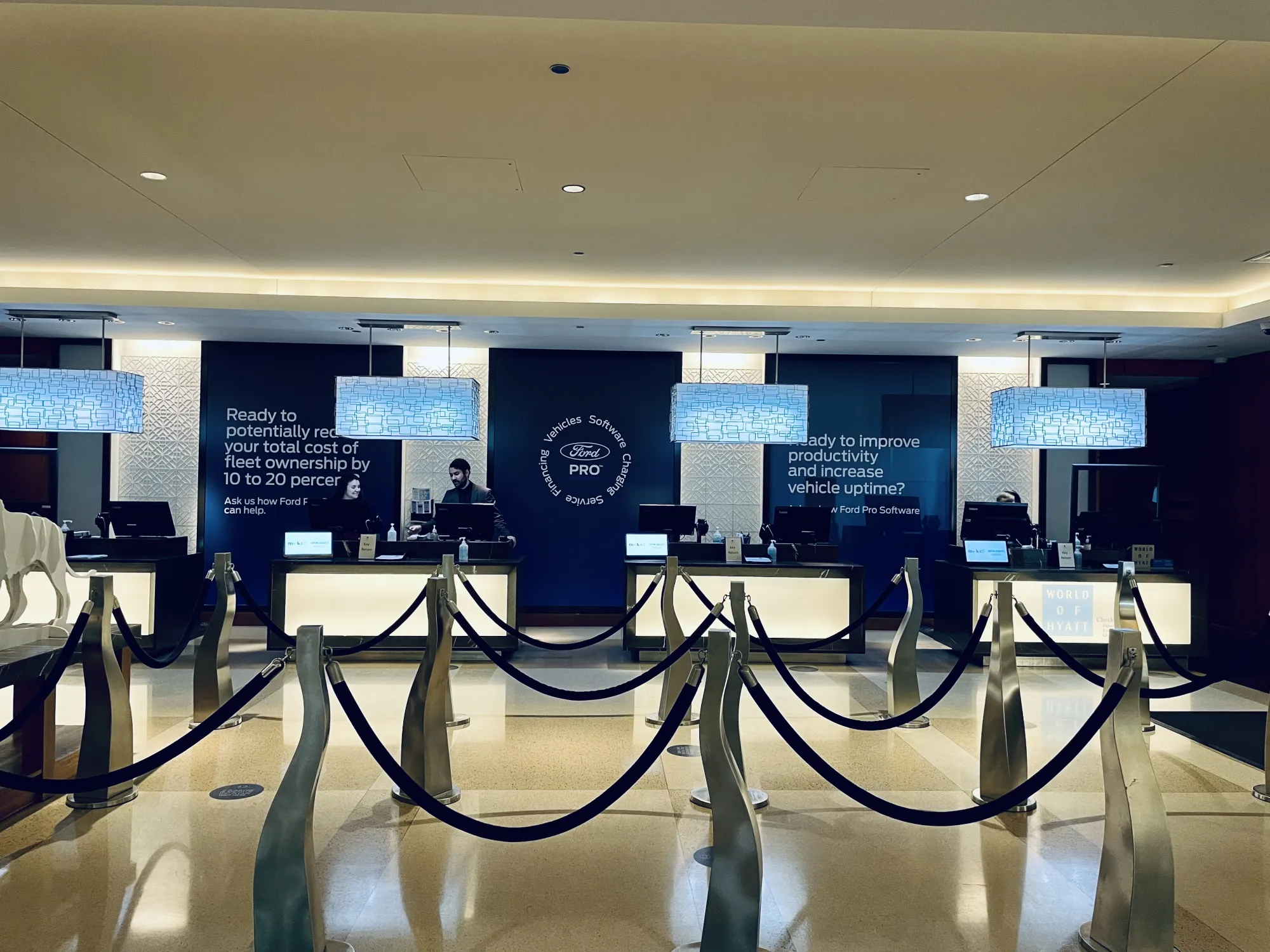 Ford Pro branded check-in lobby with staffed counters and rope-line queues