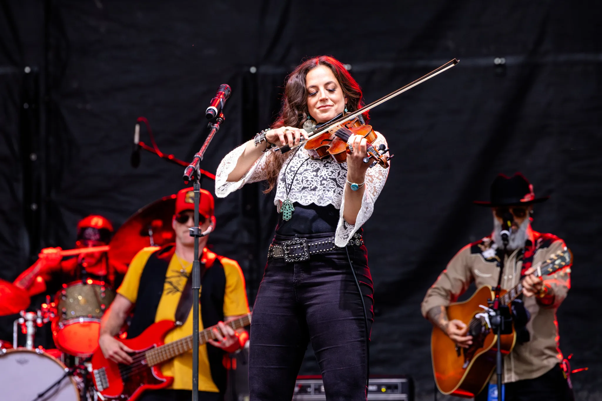 Fiddle player performing center stage with a country band at the incentive event