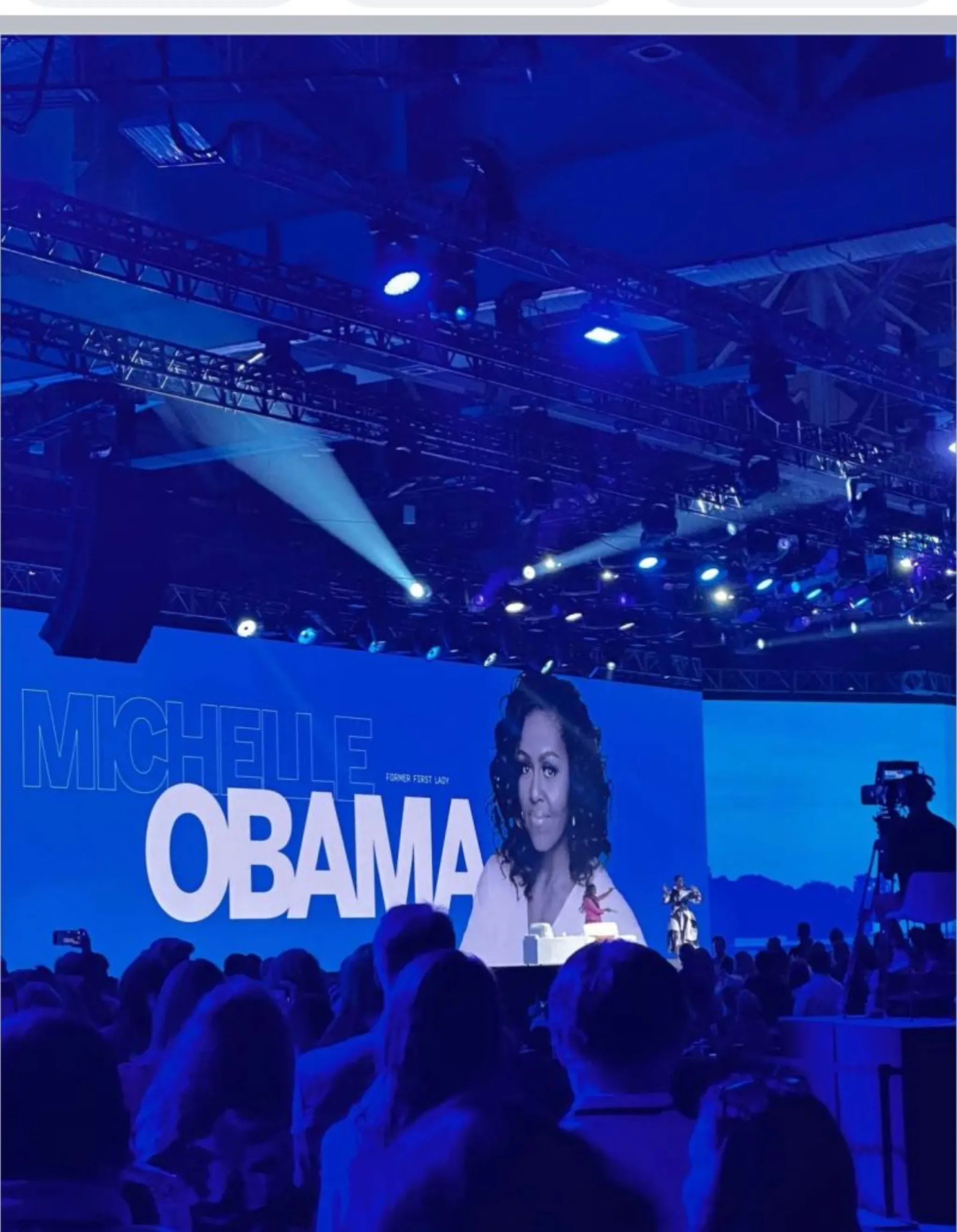 Michelle Obama introduced on the main stage screen at Qualtrics X4 Summit with crowd cheering in the arena