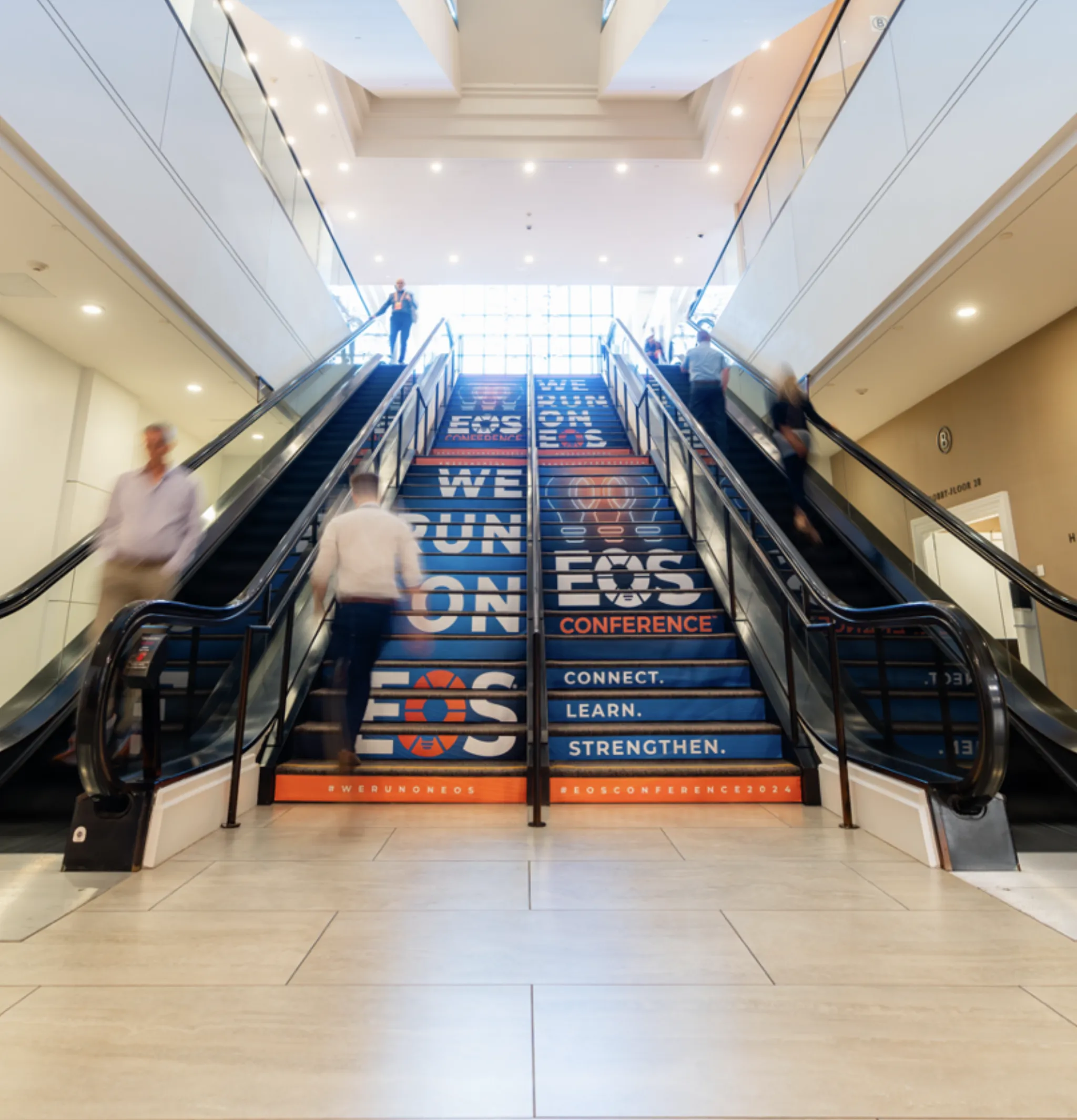 Convention center escalators wrapped in ‘We Run on EOS’ conference branding