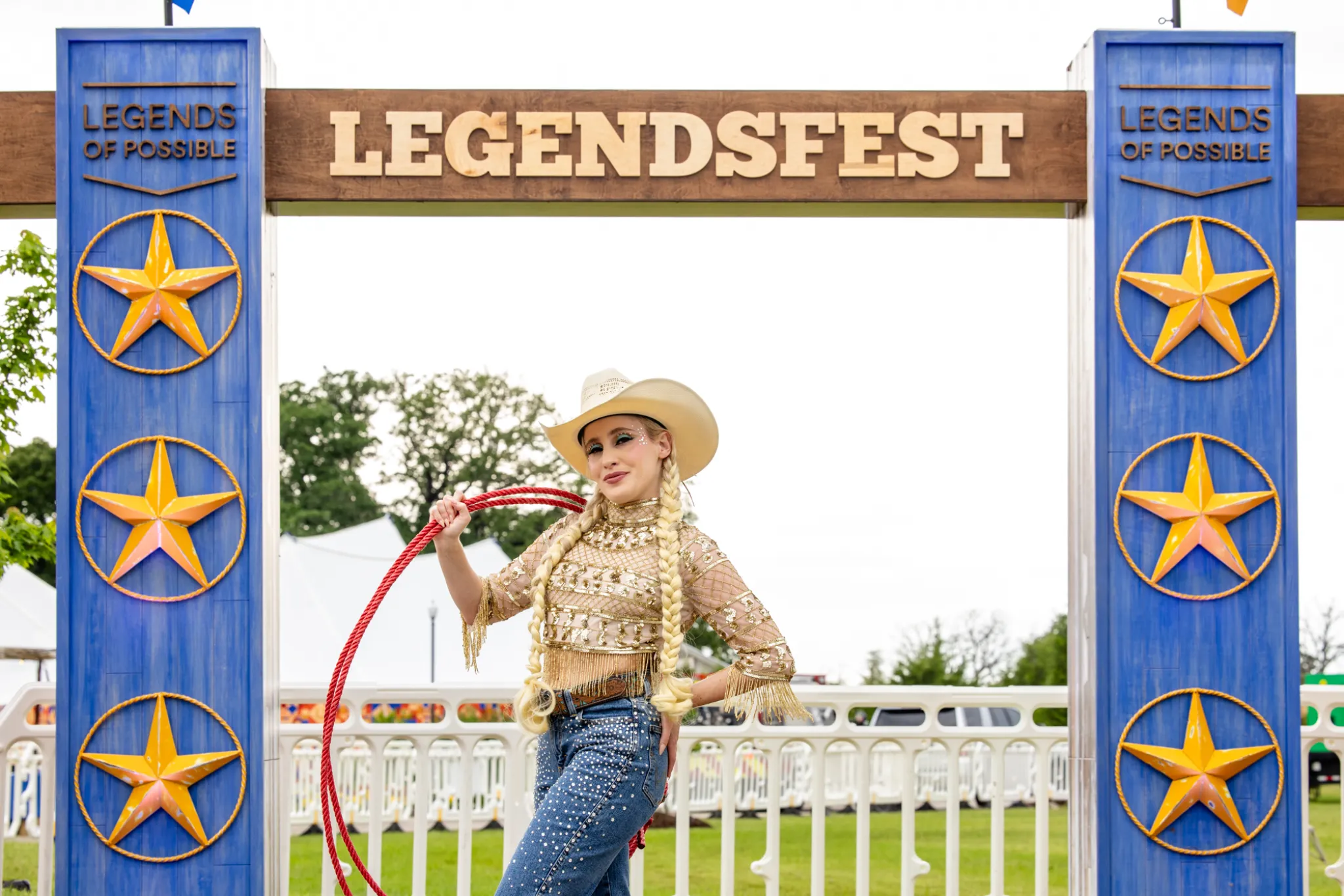 Performer with a hula hoop posing under the LegendsFest archway