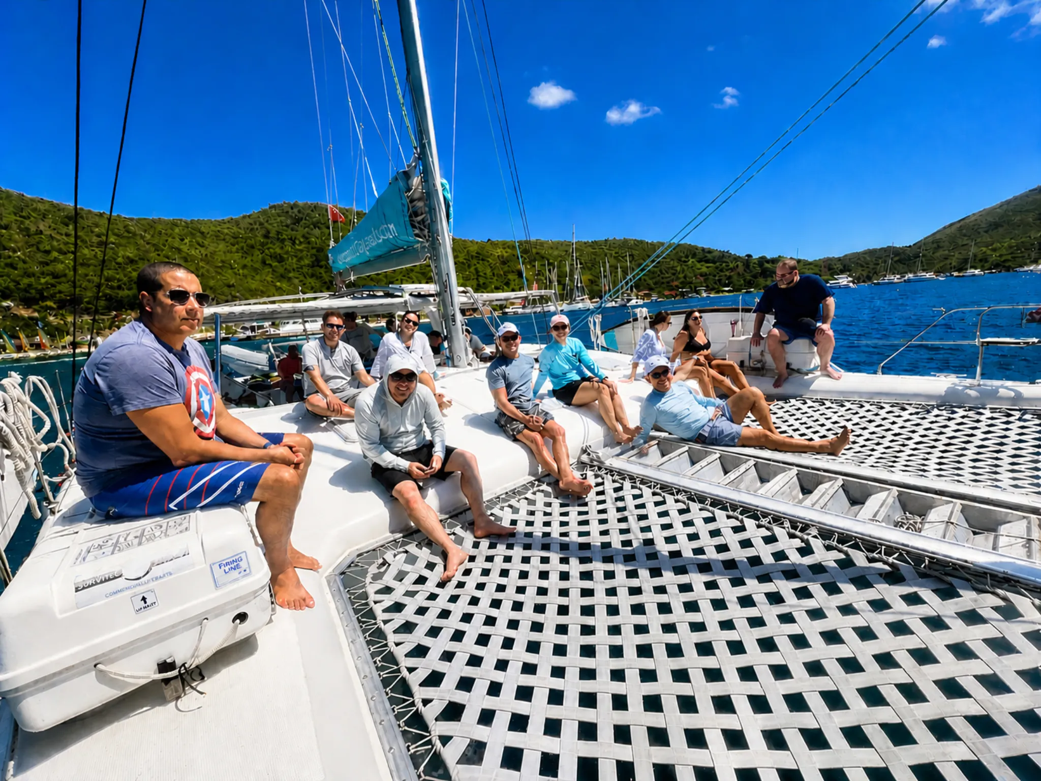 Reach for the Beach attendees relaxed on a catamaran with Virgin Gorda's hills in the background